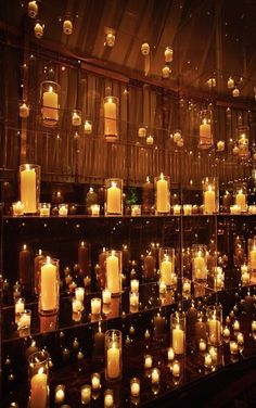 many lit candles are on display in a room