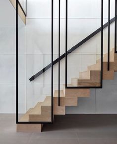 a set of stairs with black railings and wood handrails in an empty room