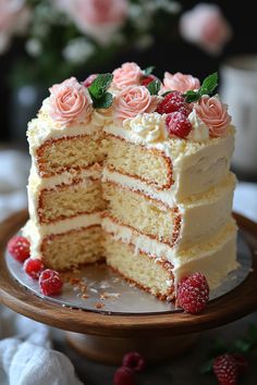 there is a cake with white frosting and raspberries on the top layer