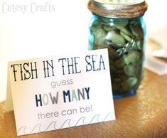 a jar filled with green beans sitting on top of a table next to a sign