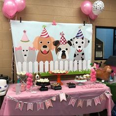 a birthday party with dogs on the fence and balloons in the air, cake and cupcakes