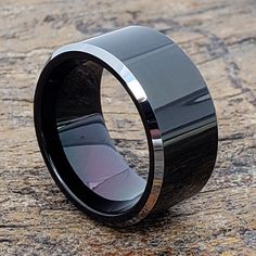 a black ceramic ring sitting on top of a rock