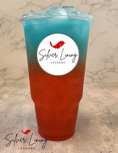 a red and blue drink sitting on top of a marble counter next to a white wall