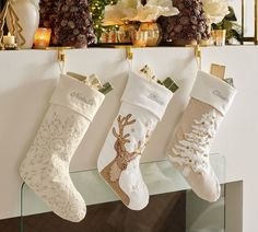 three christmas stockings hanging from a mantel