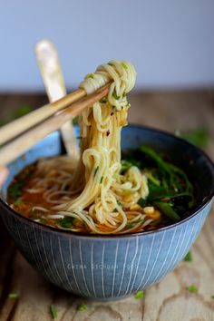 a bowl of noodles with chopsticks in it