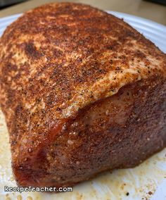 a piece of meat sitting on top of a white plate