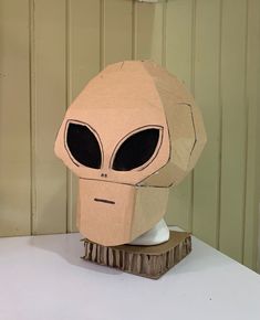 an alien head made out of cardboard sitting on top of a table