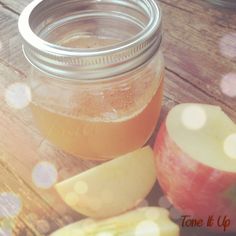 an apple cider and some sliced apples on a table