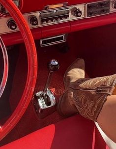 a woman's legs and boots are shown in the front seat of a car