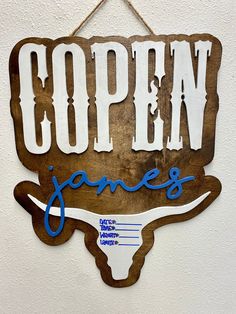 a wooden sign hanging on the side of a wall that says open james's