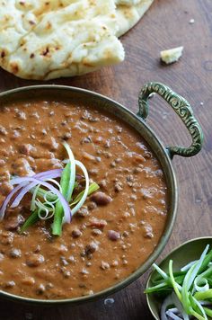 a bowl filled with beans and onions next to pita bread