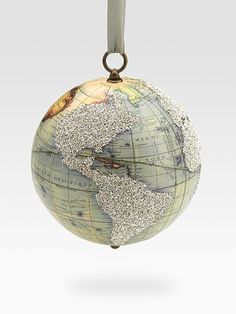 an ornament with a map on it hanging from a metal hook in the shape of a globe