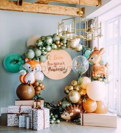 a room with balloons and decorations on the wall, including an animal balloon arch above it