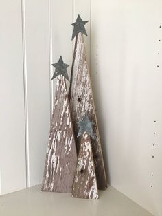 two wooden christmas trees sitting on top of a shelf