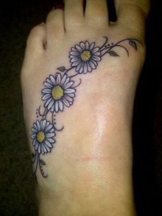 a woman's foot with daisies on it