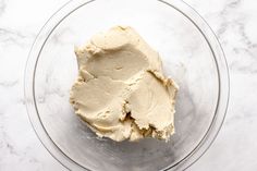 a bowl filled with cream sitting on top of a marble counter