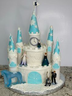 a frozen princess castle cake with figurines on top