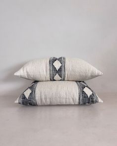 two black and white pillows sitting on top of each other