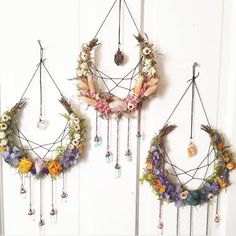 two wreaths hanging on the wall with beads and flowers attached to them, one is made from dried flowers