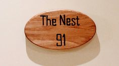 a wooden sign that says the nest 91 on it's side, hanging on a wall