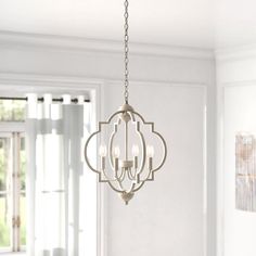 a chandelier hanging from the ceiling in a room with white walls and windows