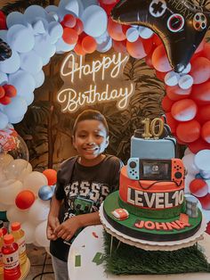 a young boy standing in front of a birthday cake