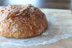 a loaf of bread sitting on top of a wooden cutting board