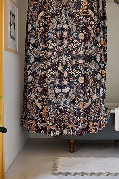 a bathroom with a shower curtain that has an ornate pattern on it and is next to a bathtub