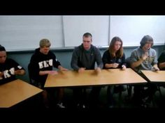 a group of people sitting around a wooden table