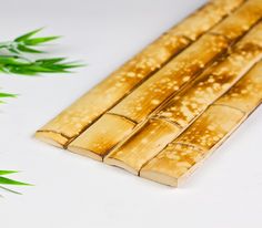 some kind of food that is sitting on a white surface with green plants in the background