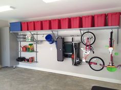 there is a bike hanging on the wall with bins and other items attached to it