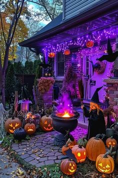 halloween decorations in front of a house with purple lights and pumpkins on the ground