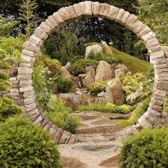 a stone arch in the middle of a garden