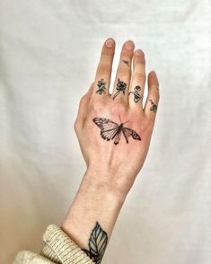 a woman's hand with a butterfly tattoo on it