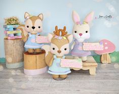 three stuffed animals are sitting on a bench in front of a wall with polka dots