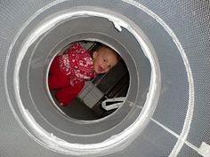 a baby is sitting in the middle of a round thing that looks like it's inside