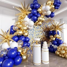 blue, white and gold balloon arch with stars on the top in front of it