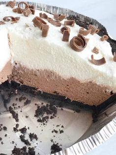 a piece of chocolate and cream pie on top of a tin foil pan with one slice missing