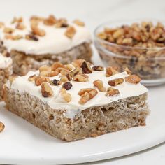 three pieces of cake on a plate with nuts and cream toppings next to each other