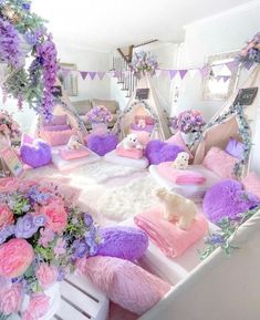 a bed with lots of pillows and flowers on top of it in a room filled with furniture