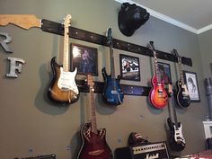 guitars are lined up on the wall in this room