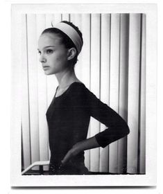 a black and white photo of a woman with her hands on her hips wearing a headband