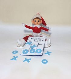 an elf is sitting on top of a book with letters and numbers around it,