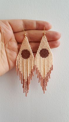 a pair of beaded earrings in the shape of a handmade eardrops