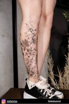 a woman's leg with flowers on it and her legs covered in black ink