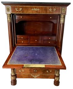 an antique wooden desk with purple velvet on the top and gold trimming around it