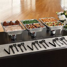 a buffet table filled with different types of food and utensils on top of it