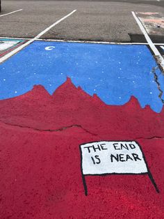 a painted parking lot with a sign that says, the end is near on it