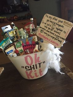 a white bucket filled with lots of assorted items on top of a wooden table