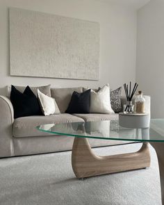 a living room with a couch, coffee table and painting on the wall above it